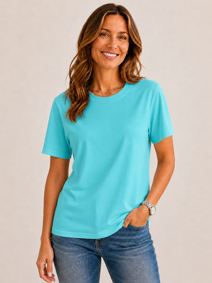 Woman wearing a LoomBasics turquoise 100% cotton crew neck top and blue jeans.