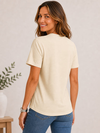Woman wearing a cream 100% cotton crew neck top from LoomBasics and blue jeans.