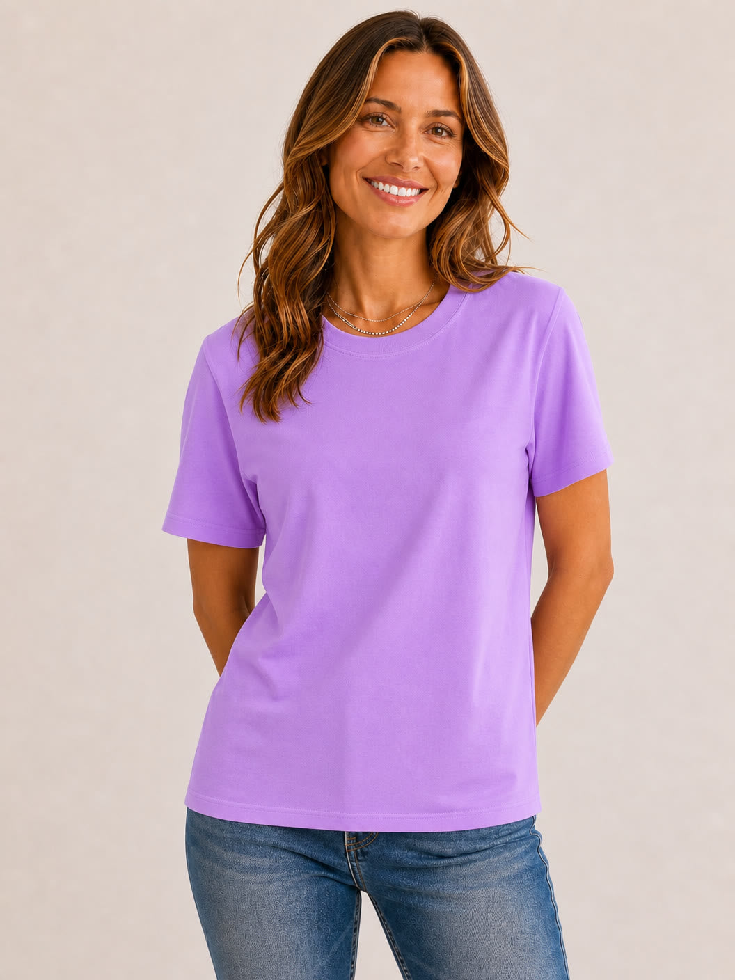 Woman wearing a LoomBasics purple 100% cotton crew neck top and blue jeans.