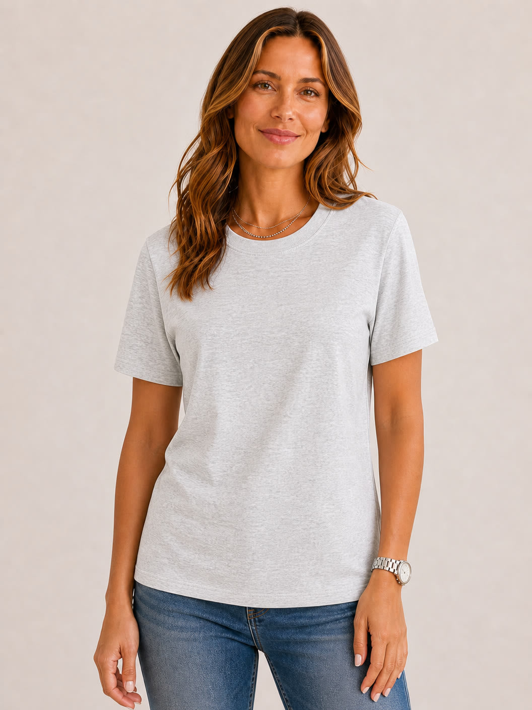 Woman wearing a light grey 100% cotton crew neck top by LoomBasics and blue jeans.