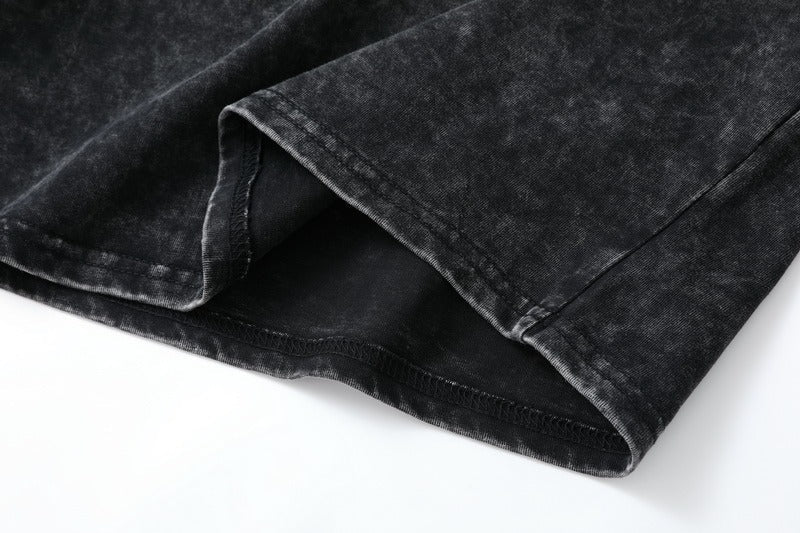 Close-up of the stitched hem of a LoomBasics 100% cotton short sleeve tee in washed black.