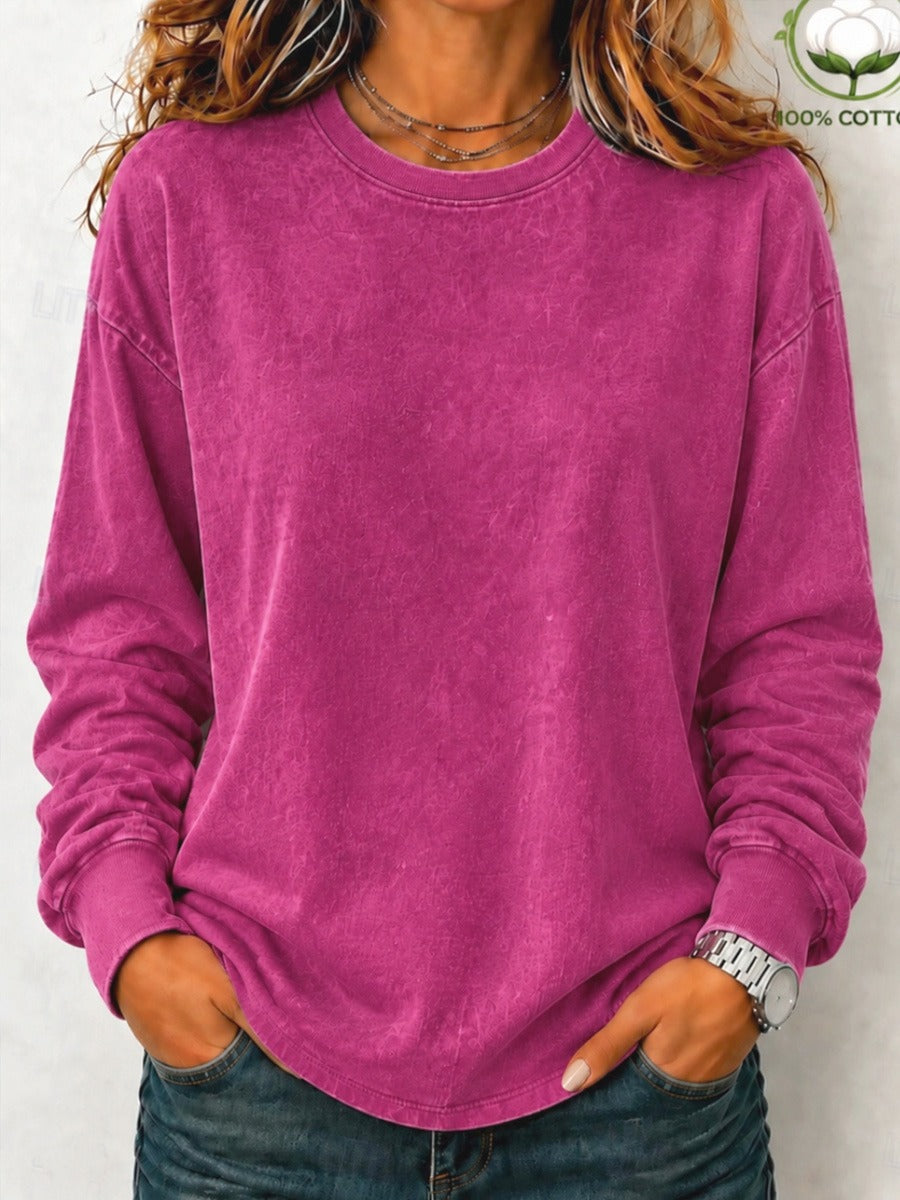 Woman wearing a LoomBasics washed magenta 100% cotton crewneck sweatshirt and blue jeans.