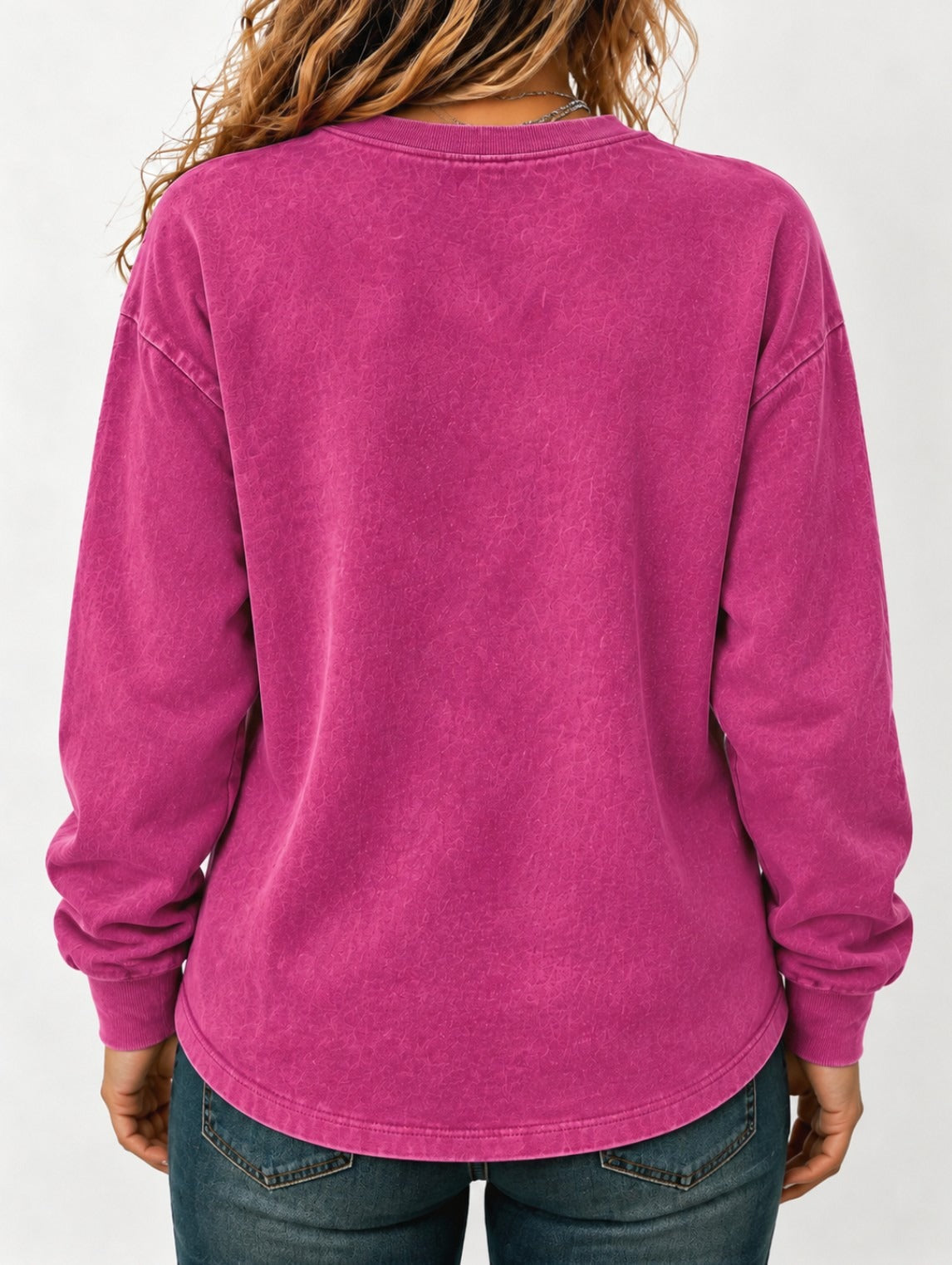 Back view of a woman wearing a washed magenta LoomBasics 100% cotton crewneck sweatshirt
