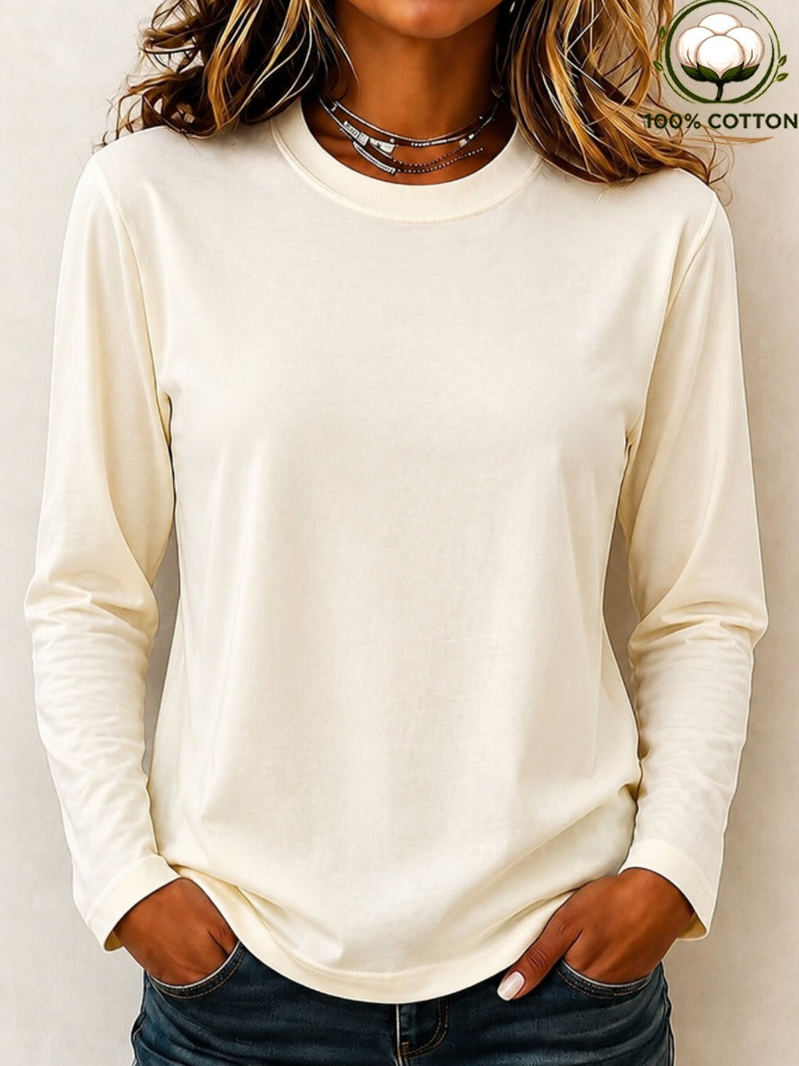 Woman wearing a LoomBasics off-white 100% cotton crew neck long sleeve tee and blue jeans.