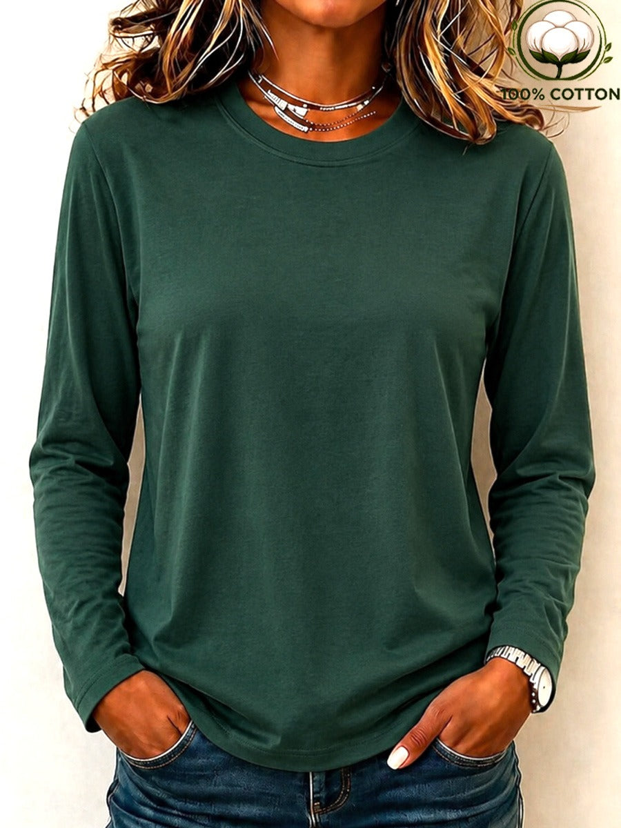 Woman wearing a LoomBasics dark green 100% cotton crew neck long sleeve tee and blue jeans.