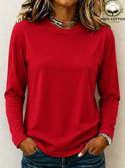 Woman wearing a LoomBasics red 100% cotton crew neck long sleeve tee and blue jeans.