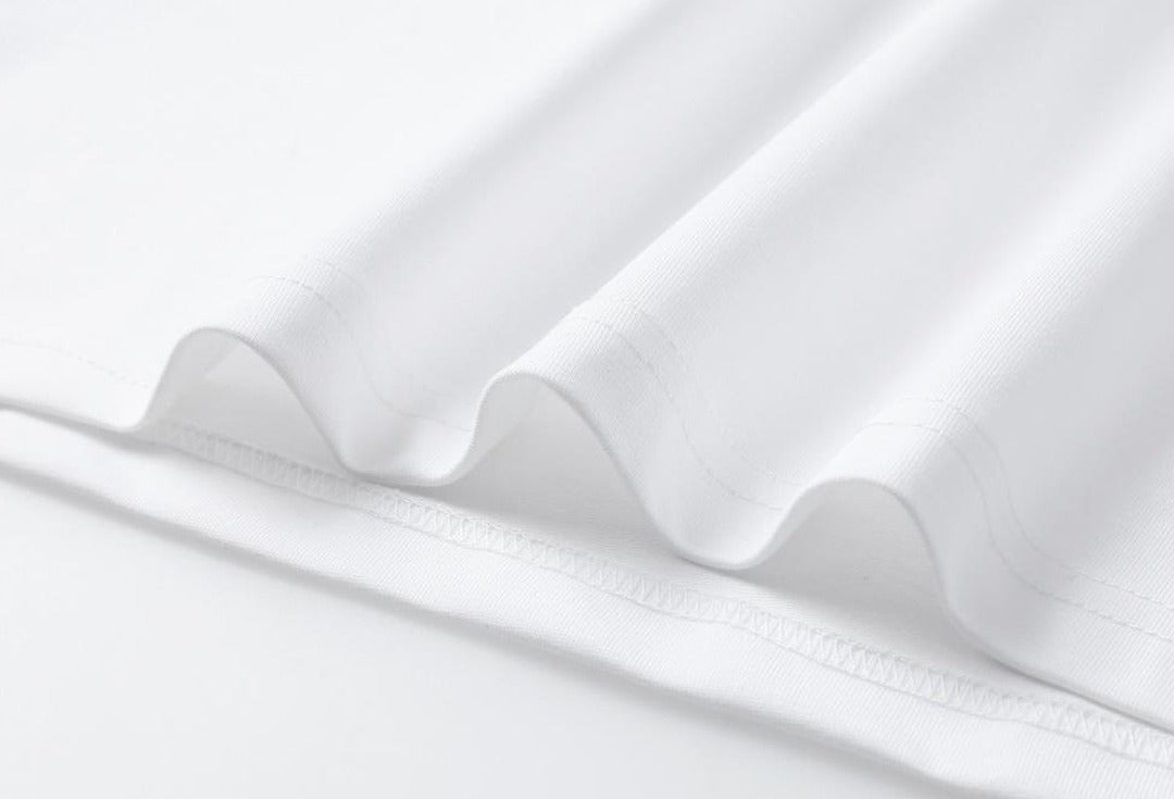Close-up of the white cotton blend fabric of a LoomBasics mini T shirt dress.