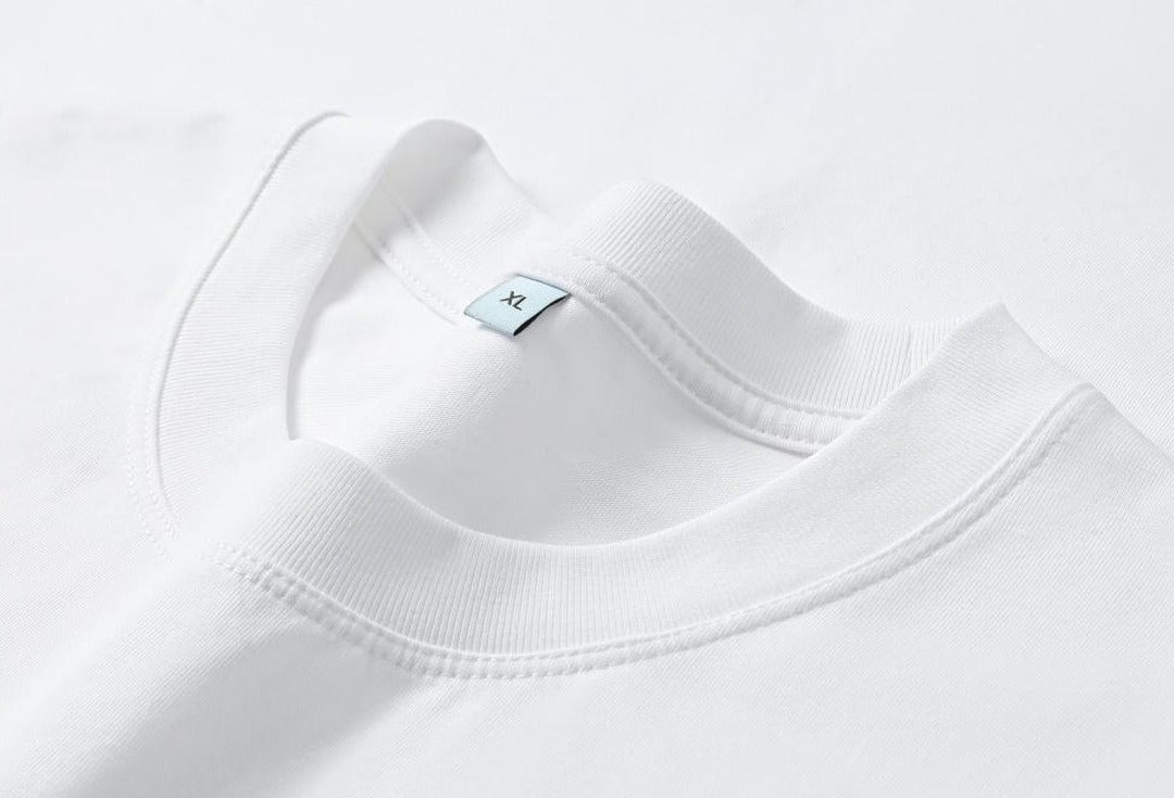 Close-up of the white cotton crew neck tee by LoomBasics featuring an XL size label.