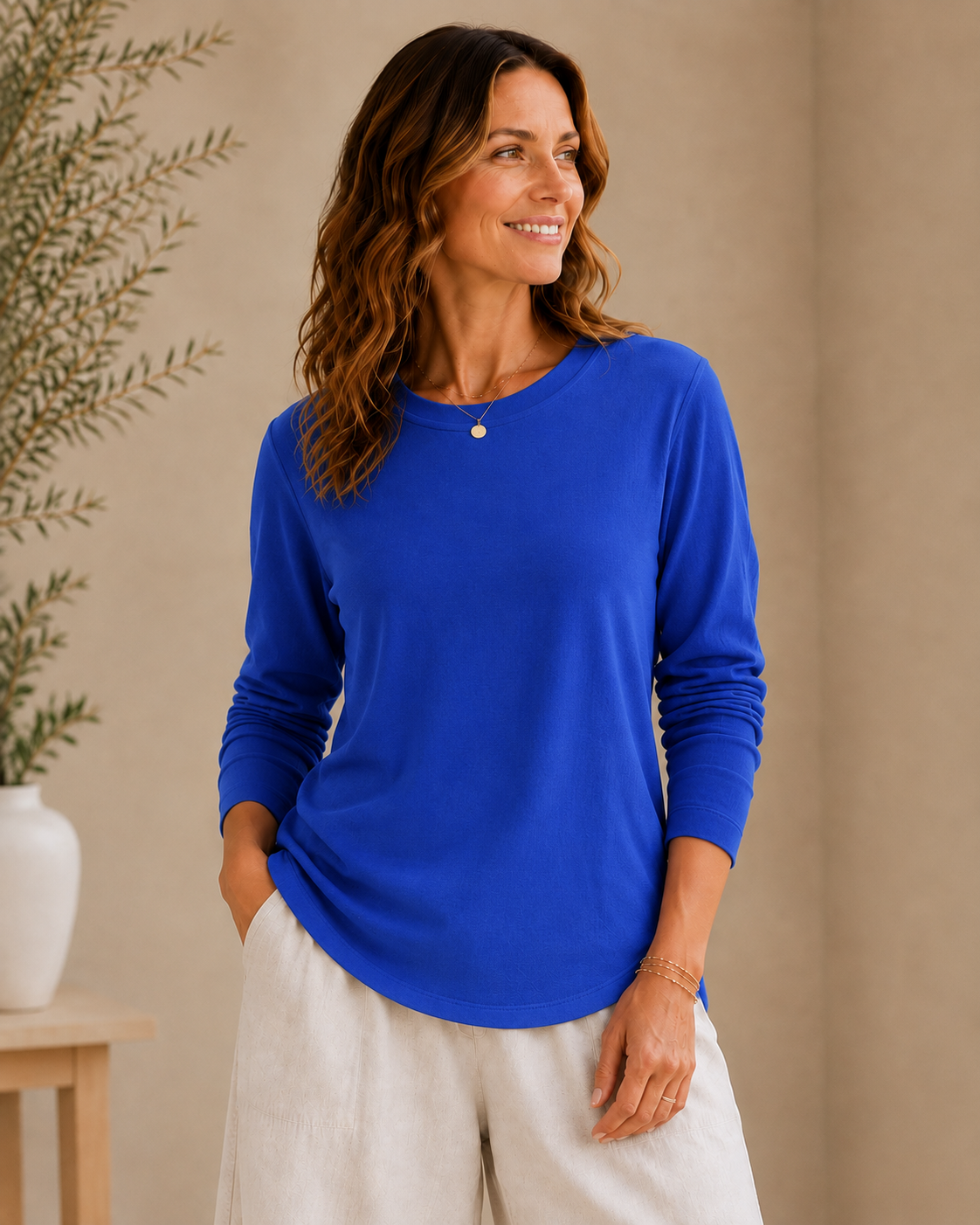 Woman wearing a royal blue LoomBasics 100% cotton crew neck tee and white linen pants.