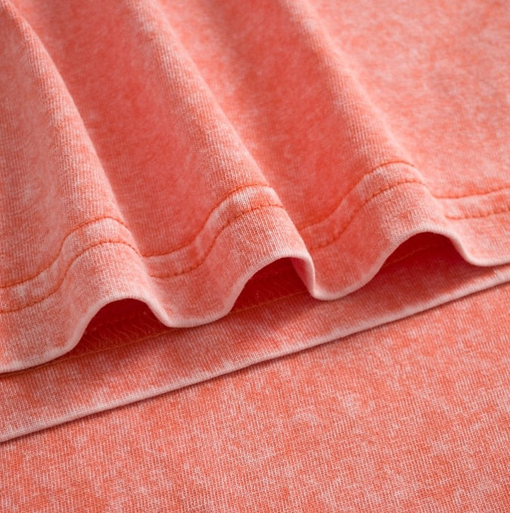 Close-up of the coral pink 100% cotton fabric and stitching of a LoomBasics crew neck t-shirt