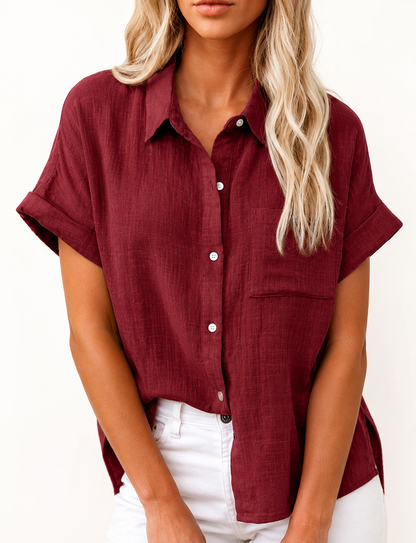 Woman wearing a burgundy LoomBasics button up 100% cotton short sleeve shirt and white pants