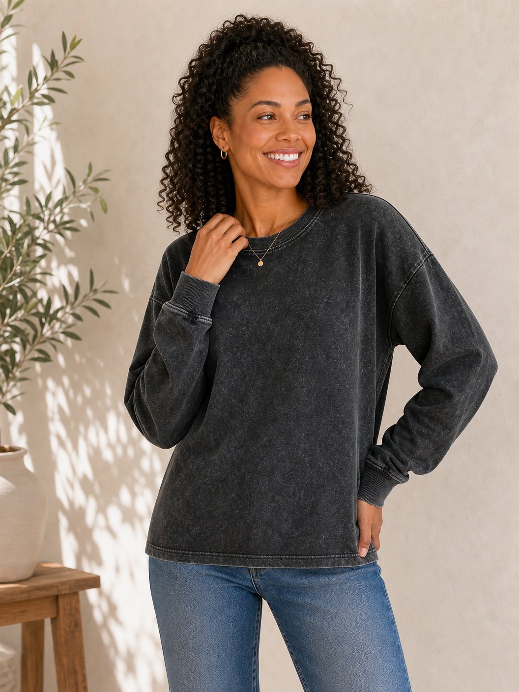 Woman wearing a LoomBasics charcoal grey 100% cotton crewneck sweatshirt and blue jeans.