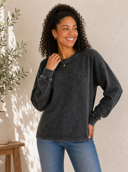 Woman wearing a LoomBasics charcoal grey 100% cotton crewneck sweatshirt and blue jeans.