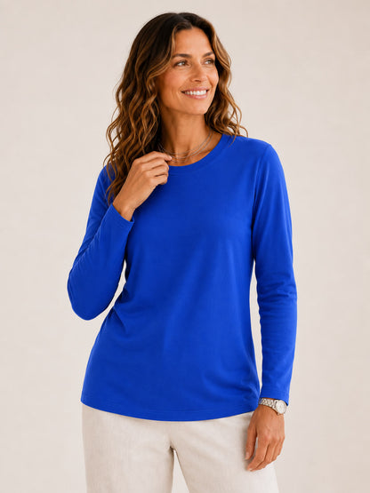 Woman wearing a LoomBasics royal blue 100% cotton crew neck long sleeve tee and white pants.
