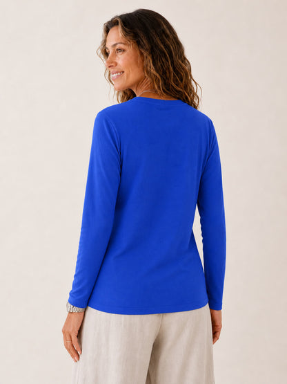 Woman wearing a LoomBasics royal blue 100% cotton crew neck long sleeve tee and beige trousers