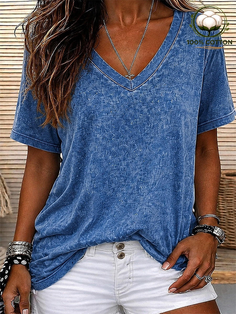 Woman wearing a LoomBasics blue acid wash 100% cotton V-neck t-shirt and white denim shorts.