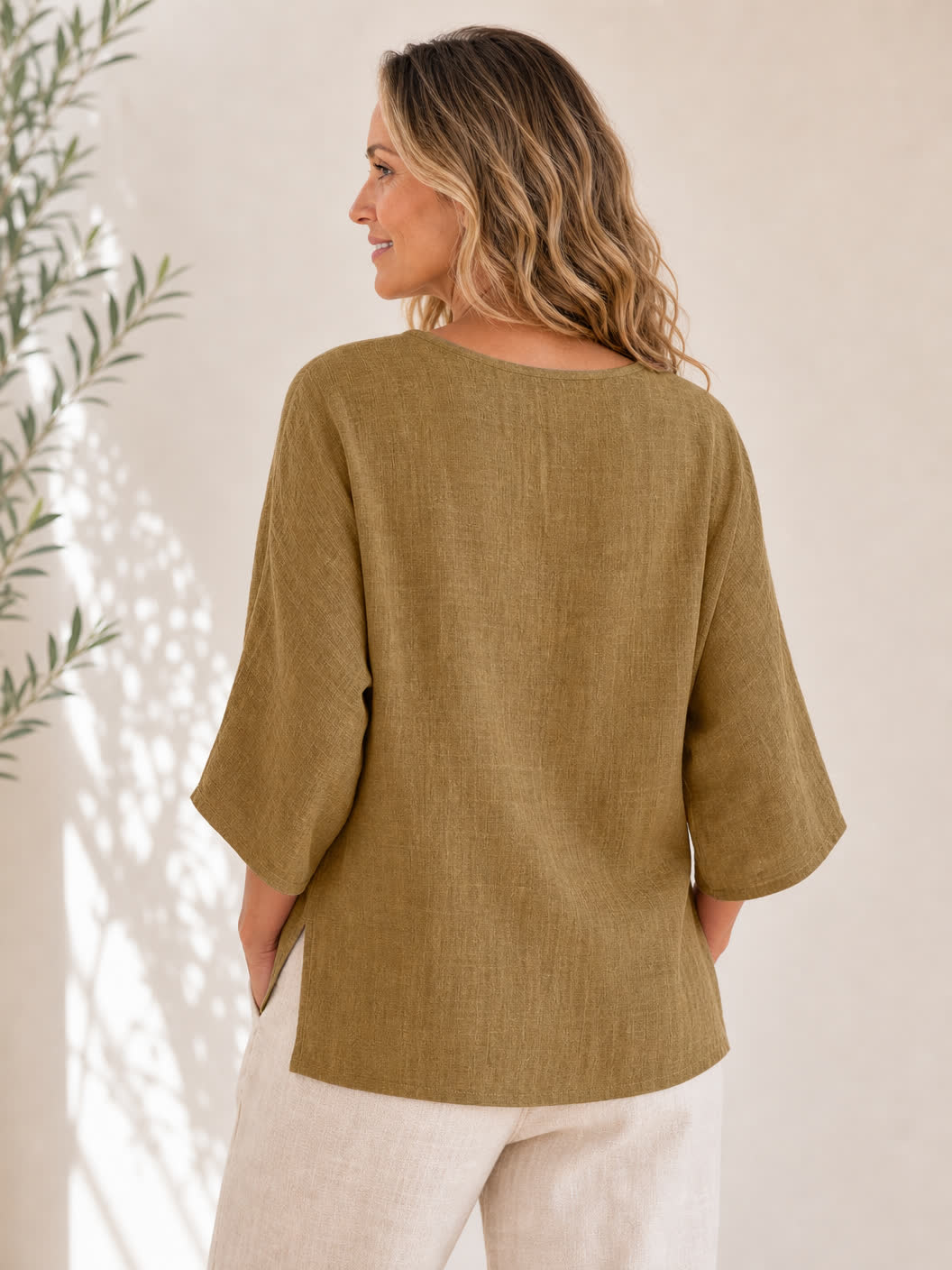 Back view of a woman wearing a LoomBasics olive green crew neck 100% cotton blouse.