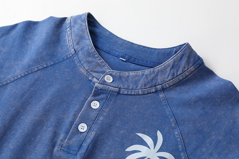 Close-up of a blue 100% cotton washed Henley tee by LoomBasics with white buttons.