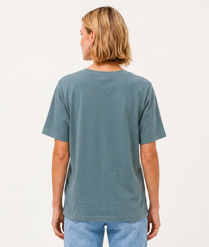 Back view of a woman wearing a LoomBasics Geometric Tropical Cotton Tee in muted blue.