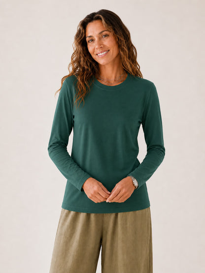 Woman wearing a LoomBasics green 100% cotton crew neck long sleeve tee and olive trousers.