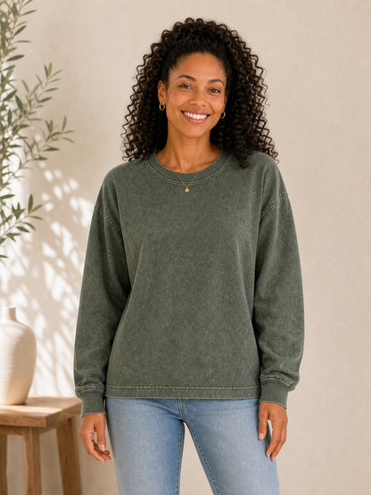 Woman wearing a LoomBasics olive green 100% cotton crewneck sweatshirt and blue jeans.