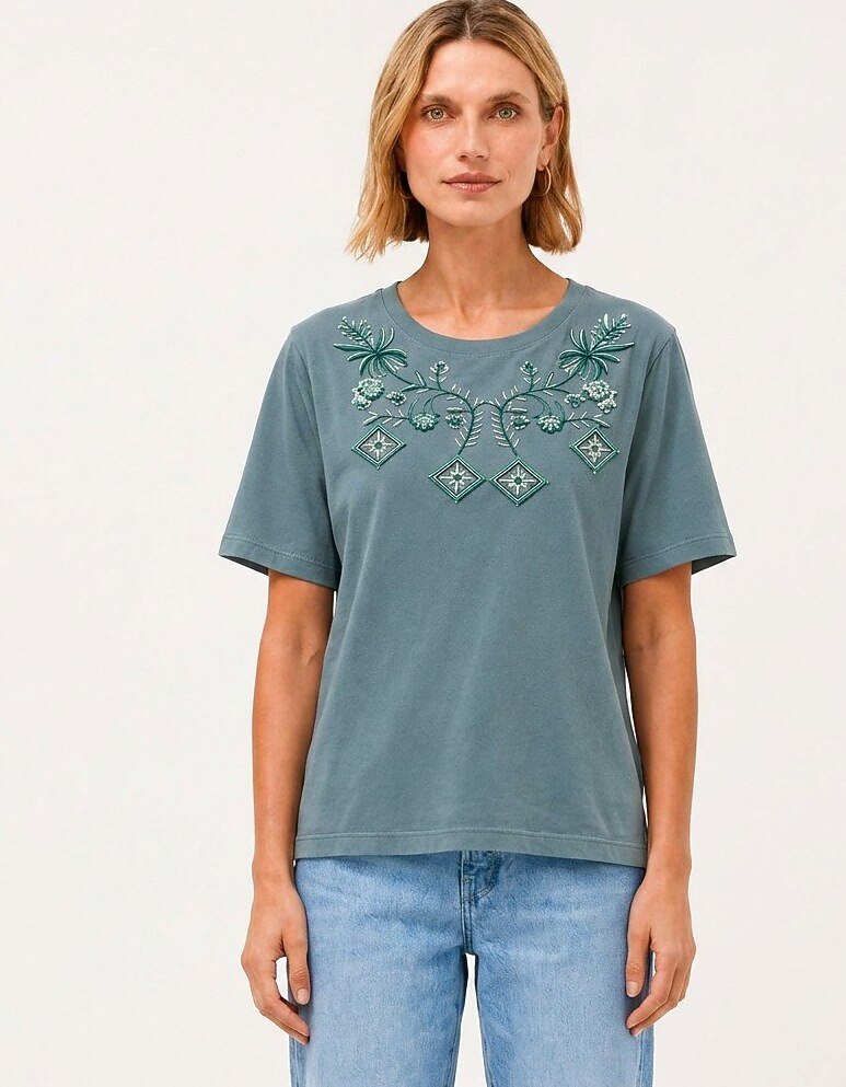 Woman wearing a LoomBasics blue geometric tropical cotton tee with floral embroidery