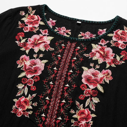 Close-up of a black LoomBasics cotton tunic shirt with red floral embroidery around the neckline.