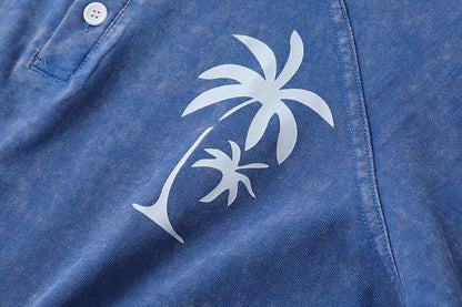 Close-up of a blue washed cotton henley tee by LoomBasics with a white palm tree print.