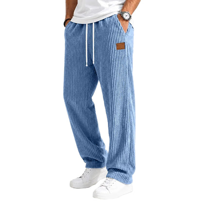 A person wearing light blue vertically striped lounge pants with a white drawstring, paired with a white t-shirt and white sneakers