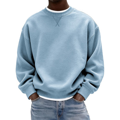 A person wearing a light blue crewneck sweatshirt with a white inner collar, paired with light blue jeans, shown from the neck down against a plain white background.