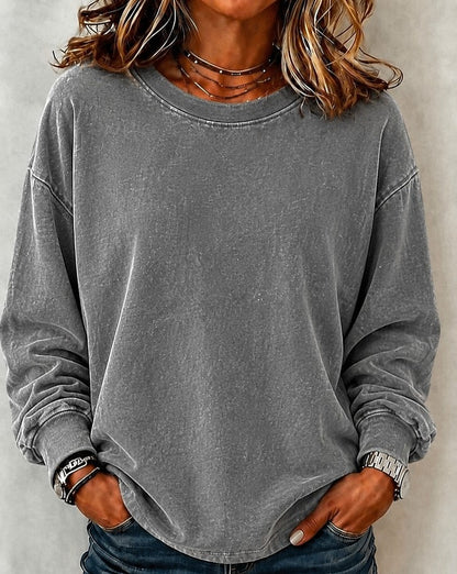 Woman wearing a LoomBasics washed grey 100% cotton crewneck sweatshirt with blue jeans