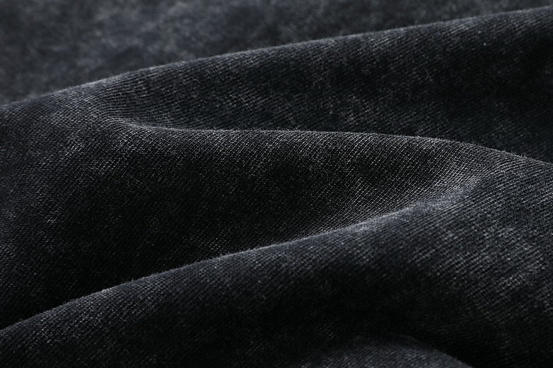 Close-up of the soft, black 100% cotton fabric texture of a LoomBasics Henley shirt.
