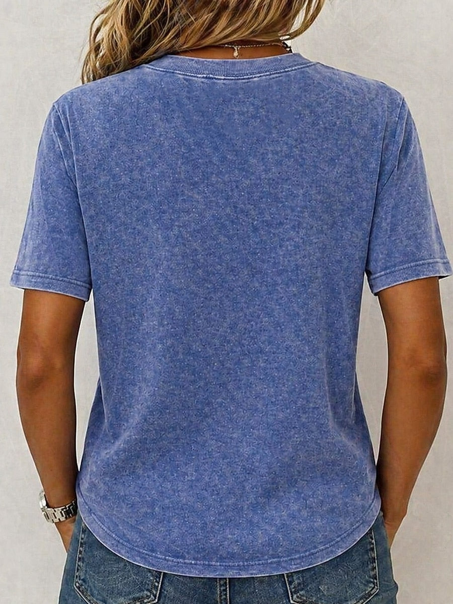 Back view of a woman wearing a LoomBasics blue acid wash 100% cotton crew neck t-shirt.