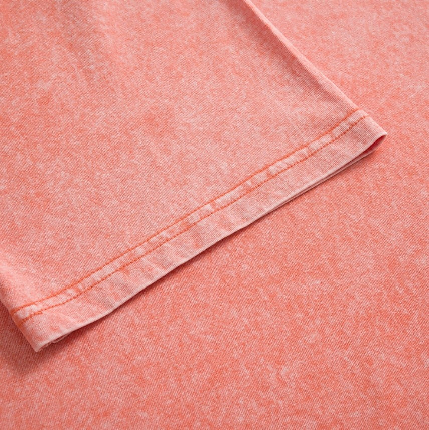 Close-up of the hem stitching on a coral pink 100% cotton crew neck t-shirt by LoomBasics