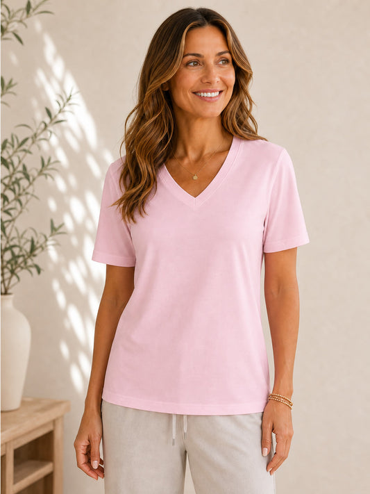 Woman wearing a LoomBasics pink 100% cotton V neck tee and grey lounge pants.