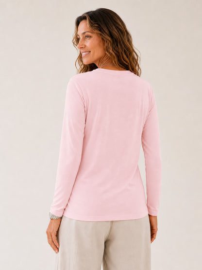 Back view of a woman wearing a LoomBasics light pink 100% cotton crew neck long sleeve tee.
