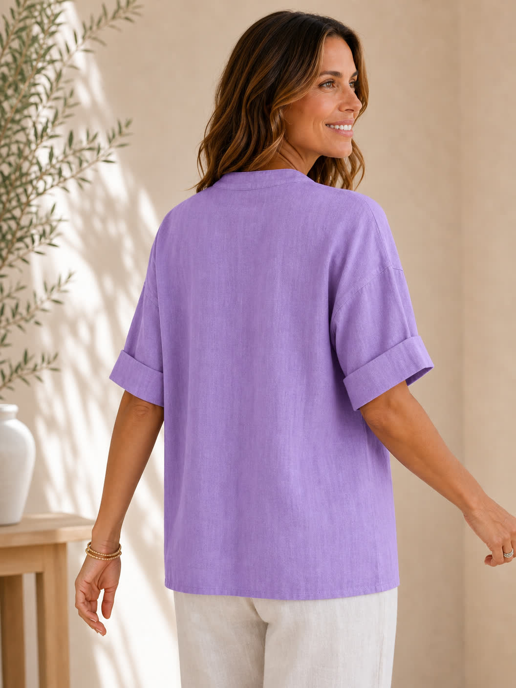 Back view of a woman wearing a purple V neck 100% cotton blouse by LoomBasics