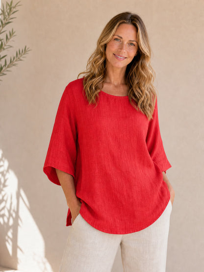 Woman wearing a red LoomBasics crew neck 100% cotton blouse and beige linen pants.