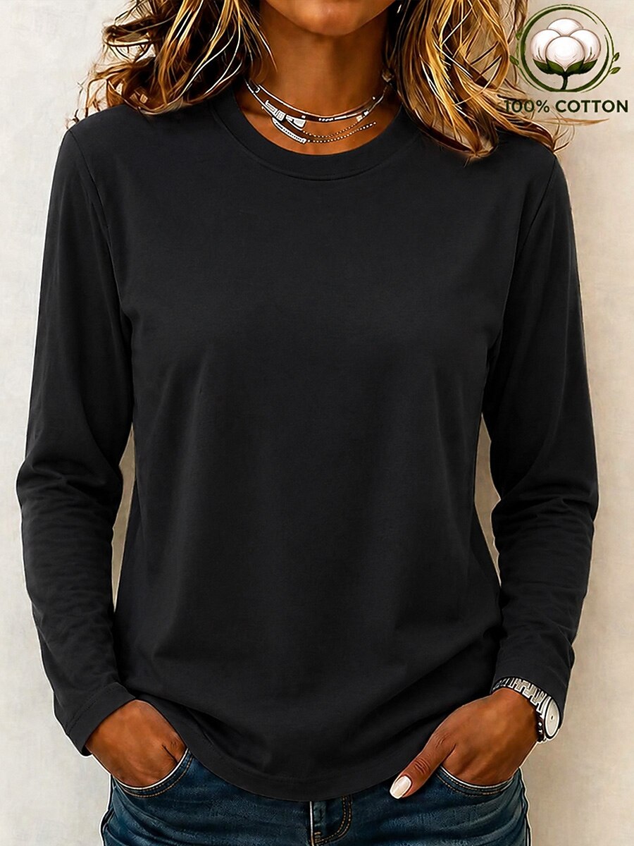 Woman wearing a LoomBasics black 100% cotton crew neck long sleeve tee and blue jeans.