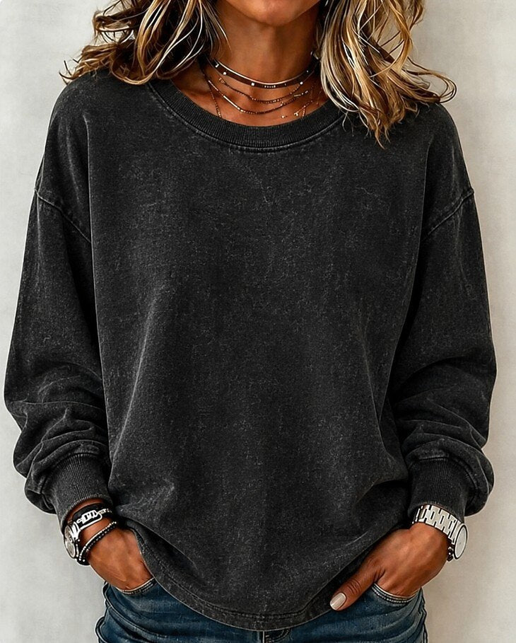 Woman wearing a LoomBasics washed dark grey cotton crewneck sweatshirt and blue jeans.