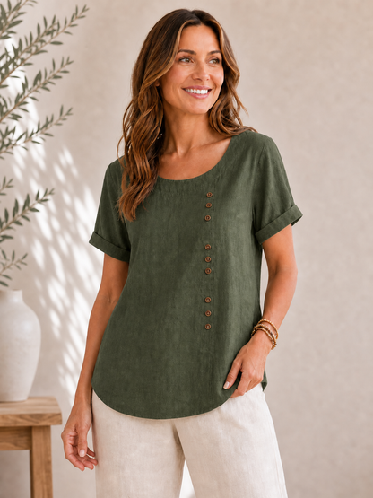 Woman wearing a LoomBasics olive green short-sleeved cotton blouse with decorative buttons.