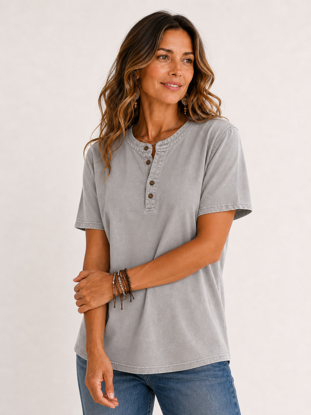 Woman wearing a grey LoomBasics 100% cotton short sleeve henley tee and blue jeans.