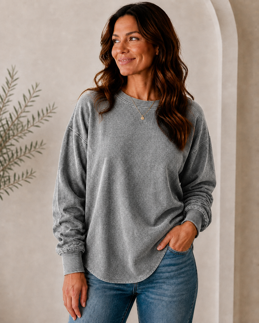 Woman wearing a LoomBasics 100% cotton grey crewneck sweatshirt and blue jeans.