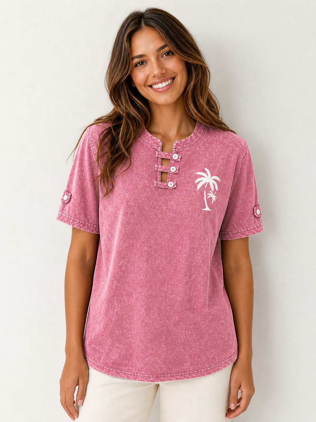 Woman wearing a LoomBasics pink acid-wash cotton henley shirt with a palm tree graphic.