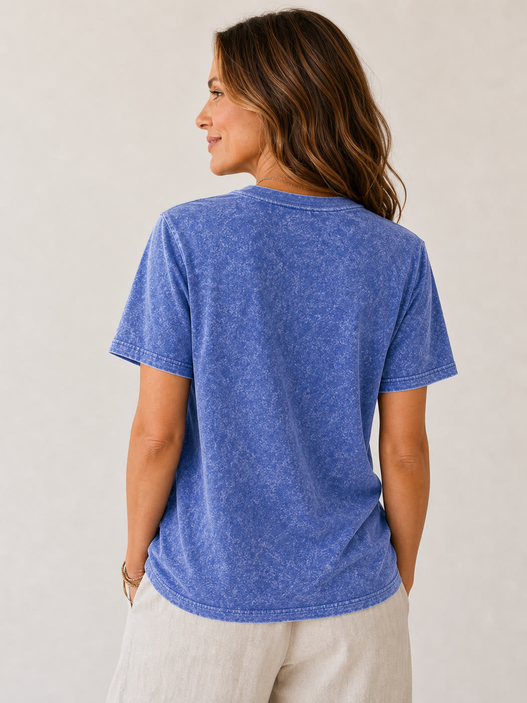 Back view of a woman wearing a LoomBasics 100% cotton crew neck tee in blue mineral wash.