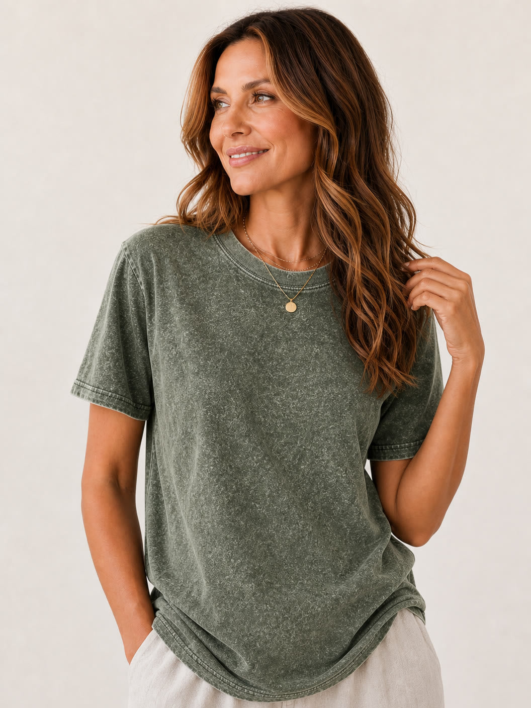 Woman wearing a LoomBasics olive green mineral wash cotton crew neck tee.