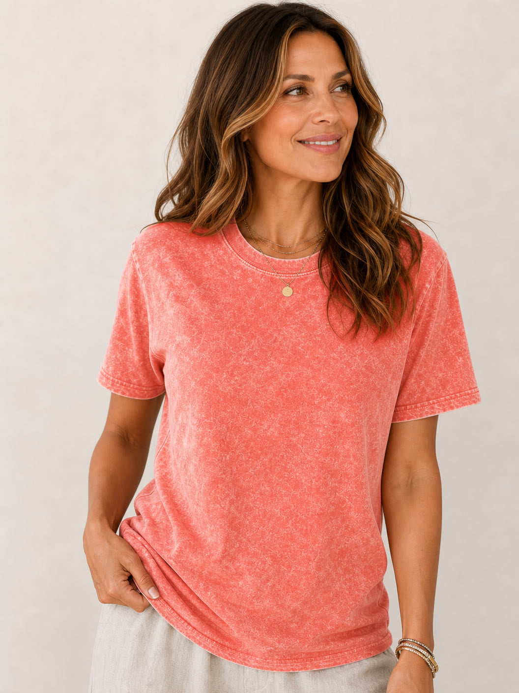 Woman wearing a LoomBasics coral red acid wash 100% cotton crew neck tee