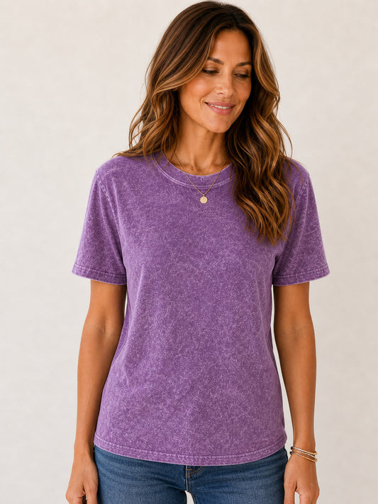 Woman wearing a LoomBasics purple mineral wash crew neck 100% cotton tee and blue jeans.