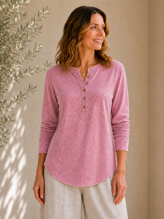 Woman wearing a LoomBasics vintage pink 100% cotton long sleeve henley shirt and beige pants.