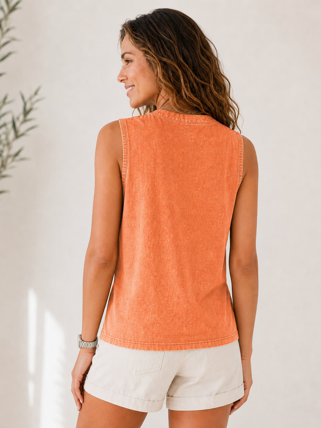 Woman wearing a LoomBasics casual orange 100% cotton sleeveless tee and beige shorts.